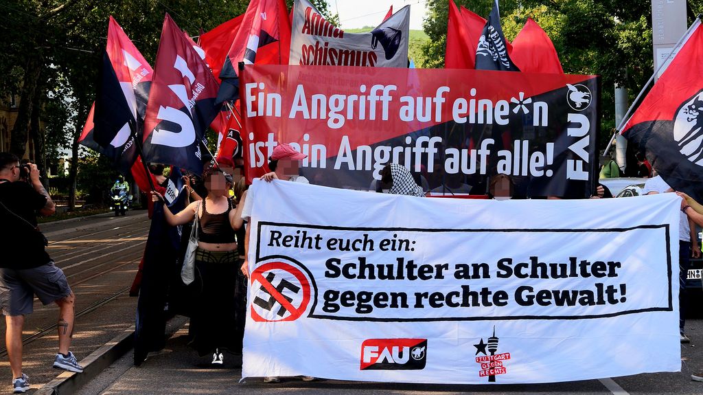 Das Foto zeigt das Fronttransparent der Demo mit dem Text "Reiht Euch ein: Schulter an Schulter gegen rechte Gewalt", dahinter ein Hochtransparent mit dem Text "Ein Angrifff auf eine*n ist ein Angriff auf alle!" - jeweils von der FAU